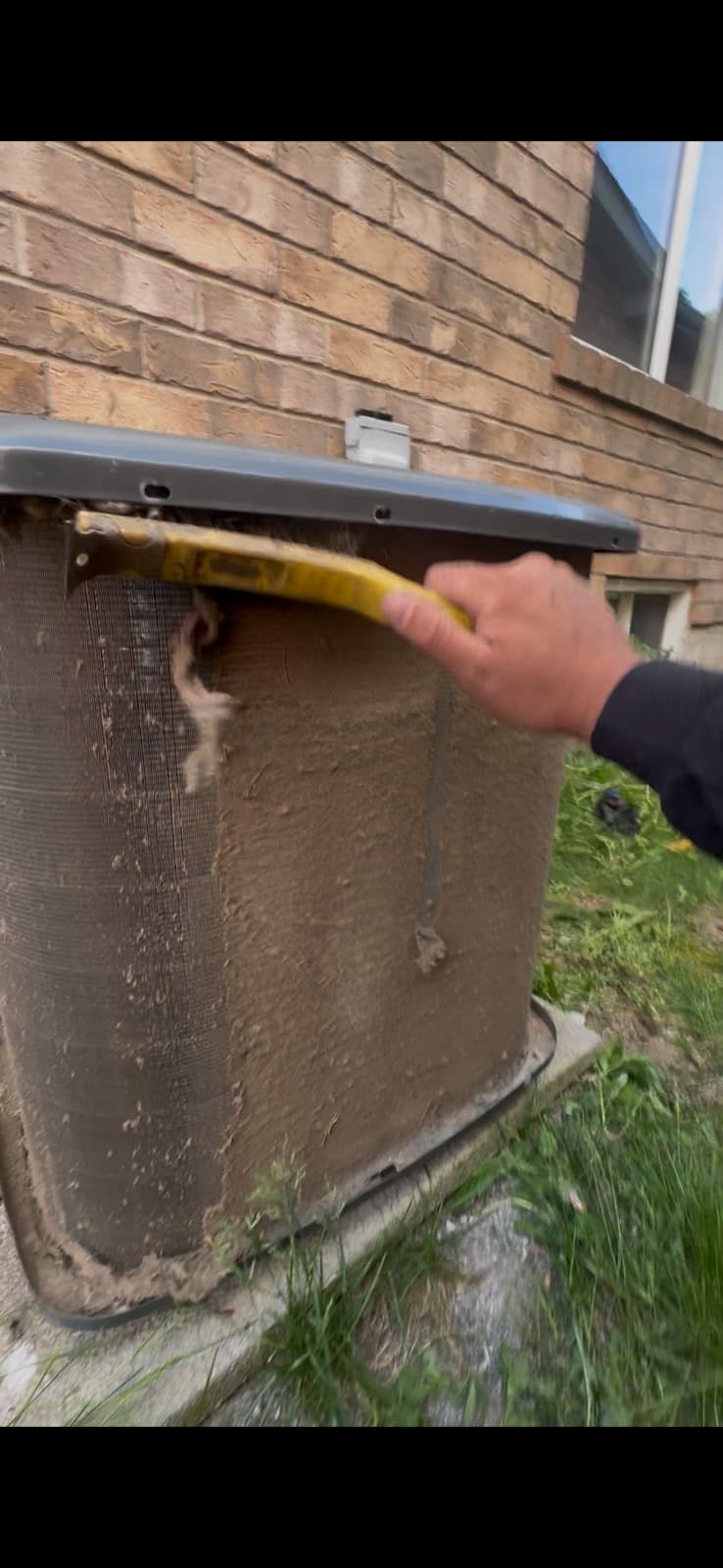 Cold Force Mechanical technician using a coil scraper on a dust-coated A/C condenser fin