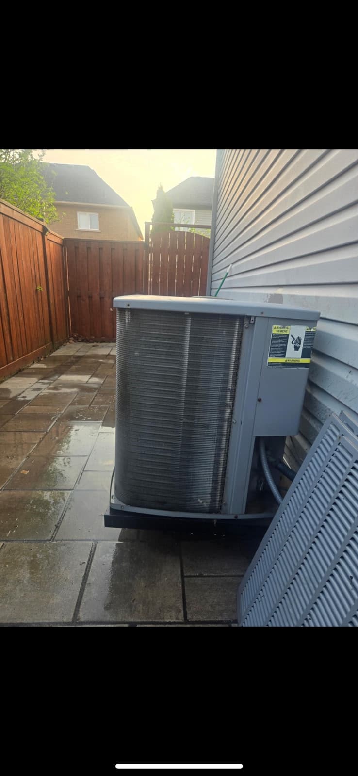 Serviced residential A/C condenser at evening, clean coil fins visible